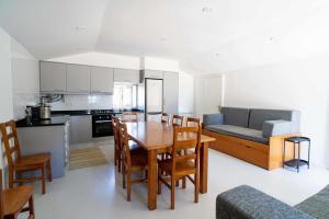 a kitchen and living room with a table and chairs at Acushla Original House Douro in Lodões