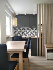 cocina con mesa de madera y sillas azules en Apartament ZDRÓJ, en Busko-Zdrój
