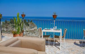 um pátio com uma mesa e cadeiras e o oceano em La Dolce Vita a Tropea em Tropea