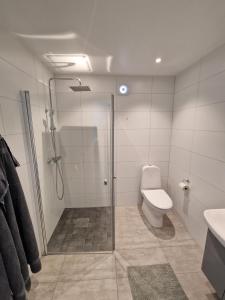a bathroom with a shower and a toilet and a sink at Kungälv-Kode Golf Club Apartments in Kode