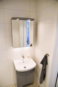 a white bathroom with a sink and a mirror at Kungälv-Kode Golf Club Apartments in Kode