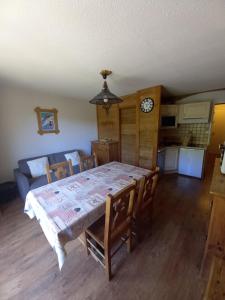 a dining room with a table and chairs and a couch at T2 vue piste Résidence Vostok Zodiaque in Le Corbier