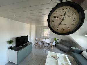 - un salon avec une grande horloge murale dans l'établissement Design Apartment am CentrO mit Homeoffice Balkon und WIFI, à Essen