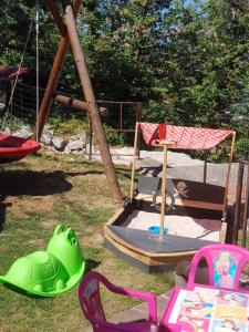 een park met een speeltuin met een schommel en stoelen bij Adriana F. in Dobreć