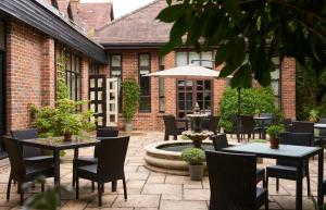 a patio with tables and chairs and a fountain at Careys Manor Hotel & SenSpa in Brockenhurst