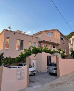 a house with two cars parked in a parking lot at ID apartments in Tivat
