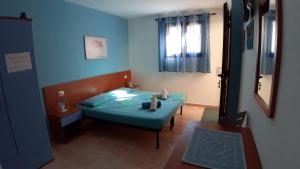 Habitación pequeña con cama y ventana en Guesthouse Affittacamere Goloritzè, en Cala Gonone