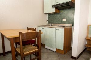 a small kitchen with a table and a sink at Residence Nube D'Argento in Sestriere