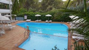 a large blue swimming pool with chairs and umbrellas at Hotel Alea in El Arenal