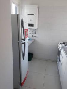 Il comprend une cuisine blanche équipée d'un réfrigérateur et d'une cuisinière. dans l'établissement Torres de Nuñez, à Buenos Aires