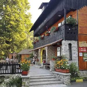 um edifício com flores em frente em Smučarska koča em Kotlje