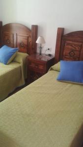 a bedroom with two beds and a table with a lamp at Apartamento Antonia 2 in Agua Amarga