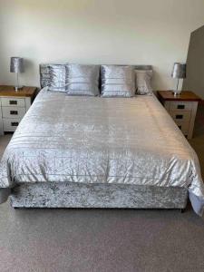 a bedroom with a large bed with two night stands at Very Large lovely double room loft apartment in Carlton Colville