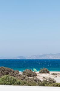 einen Strand mit grünem Sonnenschirm und das Meer in der Unterkunft Stremma Naxos in Naxos Chora