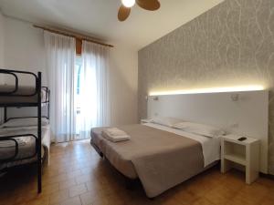 una camera da letto con un letto con una luce sul muro di Albergo Conca d'Oro a Rimini