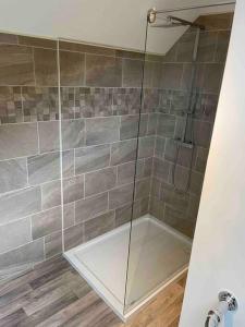 a shower with a glass door in a bathroom at Very Large lovely double room loft apartment in Carlton Colville