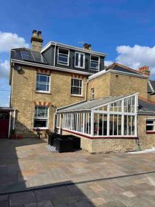 a large brick building with a greenhouse in front of it at Very Large lovely double room loft apartment in Carlton Colville