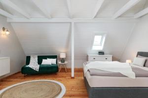 Atelierhaus auf der Insel Werder mit Garten, W-Lan und Netflix في Gallin: غرفة نوم بسرير واريكة وكرسي