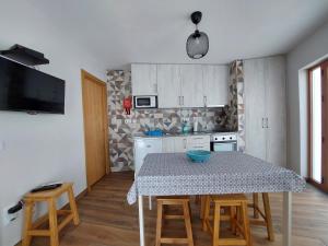 Una cocina con una mesa y sillas en una cocina. en Casa da Igreja, en Sabugueiro