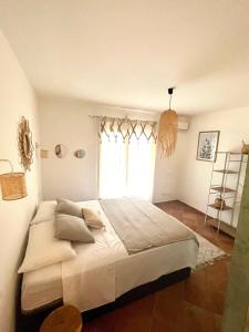 um quarto com uma cama grande e uma janela em Chez Adri et Léa em Biguglia