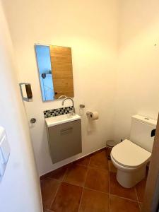 uma casa de banho com um WC e um espelho. em Chez Adri et Léa em Biguglia
