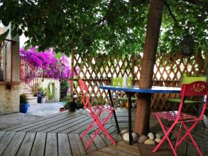 a table and chairs sitting under a tree on a deck at Chez Adri et Léa in Biguglia
