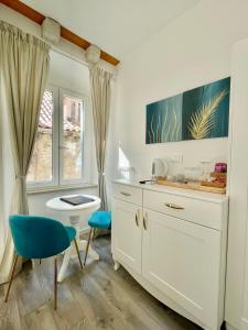 a white kitchen with a blue chair and a sink at Ida Old Town Rooms in Dubrovnik
