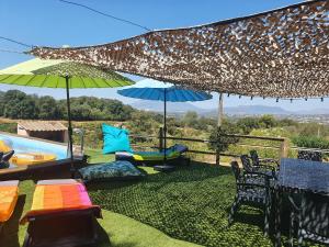 un patio con sillas y sombrillas y una piscina en FORCONE, en Cauro