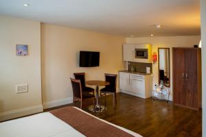 a room with a bed and a kitchen with a table at Marylebone Inn in London