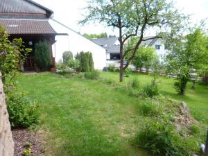 une cour avec de l'herbe verte et une maison dans l'établissement Ferienwohnung Vreni, à Gersfeld