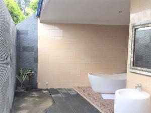 a bathroom with a tub and a sink at Villa - Warung AromaChampuhan in Mayong +6 photos