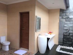 a bathroom with a white sink and a toilet at Villa - Warung AromaChampuhan in Mayong