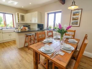 een keuken en eetkamer met een houten tafel bij Dairy Cottage in Carnforth