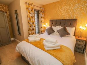 een slaapkamer met een bed met handdoeken erop bij Dairy Cottage in Carnforth