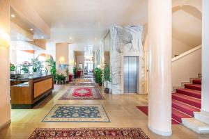 un pasillo con alfombras en el suelo de un edificio en Hotel Royal, en Bibione