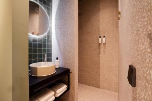 bagno con lavandino e specchio di Heavens Hotel a Hoorn