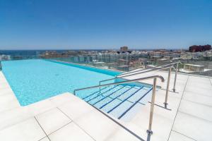 a swimming pool on the roof of a building at INF42M- Modern city apartment, families only in Estepona