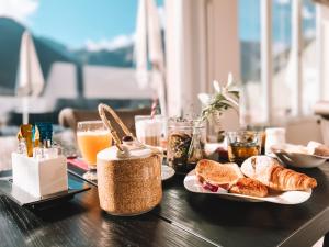 a table topped with plates of bread and orange juice at Hôtel Le White - Le 42 Restaurant in Champéry