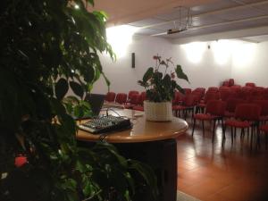 a room with red chairs and a table with a keyboard at Cala Rosa Club Hotel in Stintino
