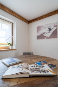 un livre ouvert assis au-dessus d'une table en bois dans l'établissement Chalet Ines, à Vodo Cadore