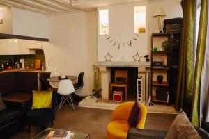 a living room with a fireplace and a table at Cozy 2-Pièces au Coeur du Haut-Marais in Paris