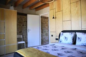 a bedroom with a bed and a door and a chair at vakantiewoning Odiel & Gabrielle in Montchevrier