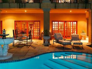 a swimming pool with two chairs and a fountain at Tuareg Guest House in Midrand