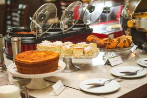 a buffet of cakes and pastries on a table at Hotel Dan Inn Uberaba & Convenções in Uberaba
