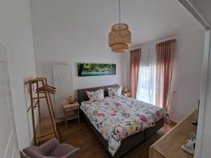 a bedroom with a bed and a chair and a window at Ferienwohnung Eifeloase in Nideggen