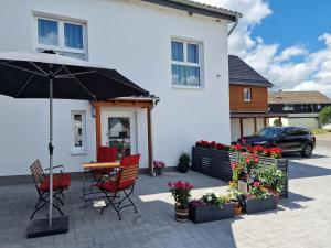 a patio with a table and chairs and an umbrella at Ferienwohnung Eifeloase in Nideggen