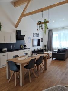 尼德根的住宿－Ferienwohnung Eifeloase，厨房以及带木桌和椅子的客厅。