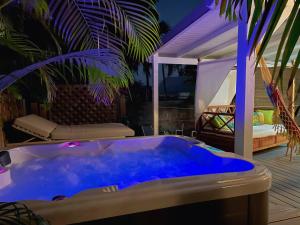 - une grande baignoire bleue dans une chambre avec un lit dans l'établissement Bungalow Karaib Lodge, à Saint-François
