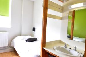 a bathroom with a bed and a sink and a mirror at IOU Hebden Bridge Hostel in Hebden Bridge