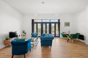 een woonkamer met blauwe stoelen en een tafel bij Luxury Split Level 2 Bed Apartment in Ramsgate